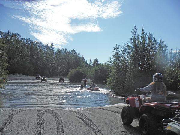 Karen Duquette waiting to cross the river on her ATV
